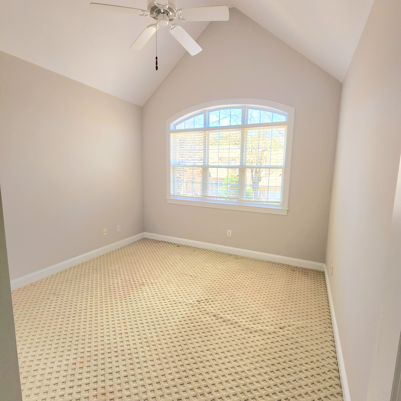 upstairs bedroom 1 with cathedral ceiling and large window